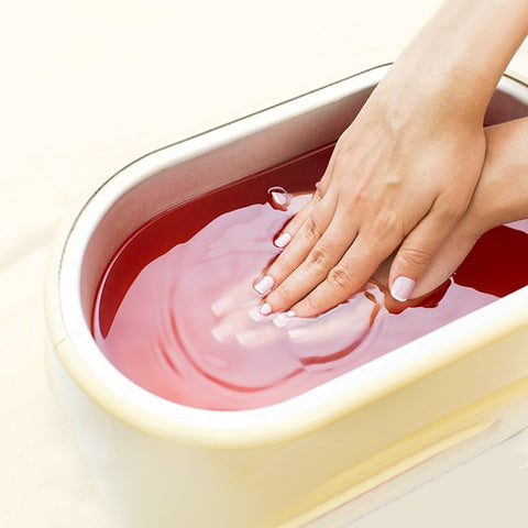 Dipping hands in paraffin wax for a paraffin wax spa treatment. 