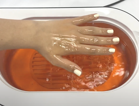 Peach Paraffin Wax Treatment with Woman Dipping Her Hand in