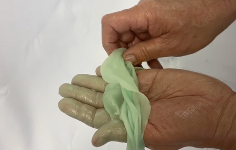 Peeling off paraffin wax on mans hand