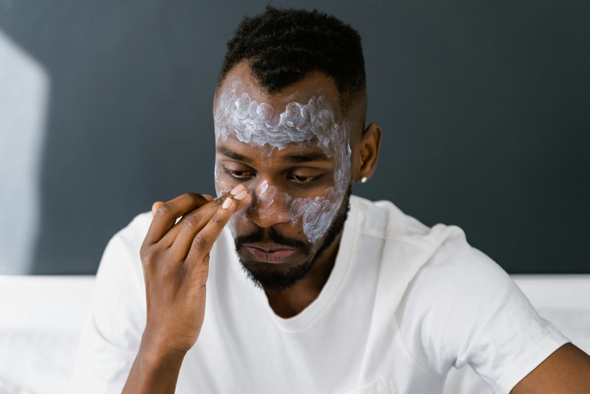 man applying face mask to his face