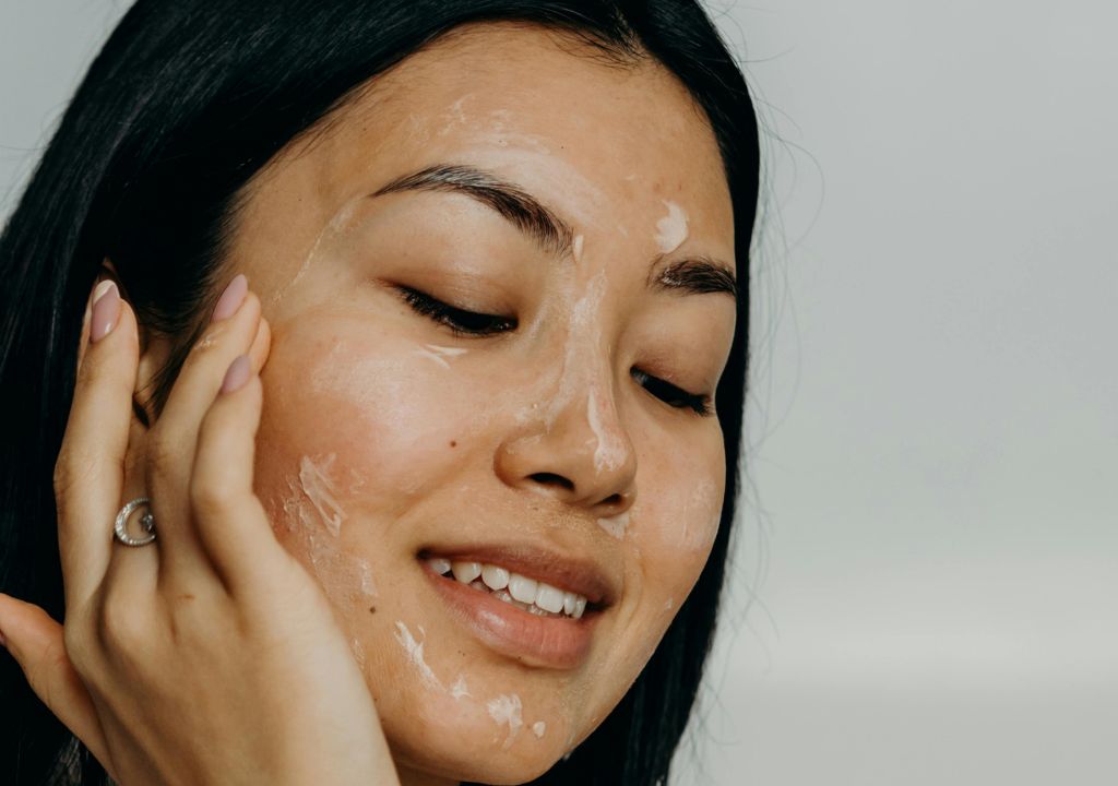 person massaging skincare into her face