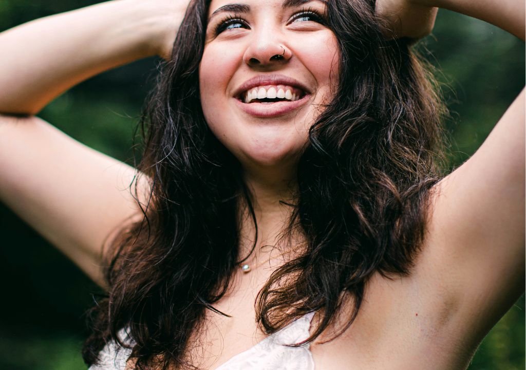 lady smiling with both arms above her head