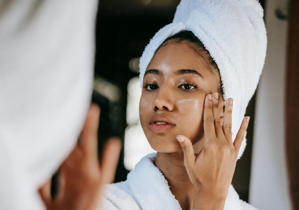 Lady applying sunscreen to her face