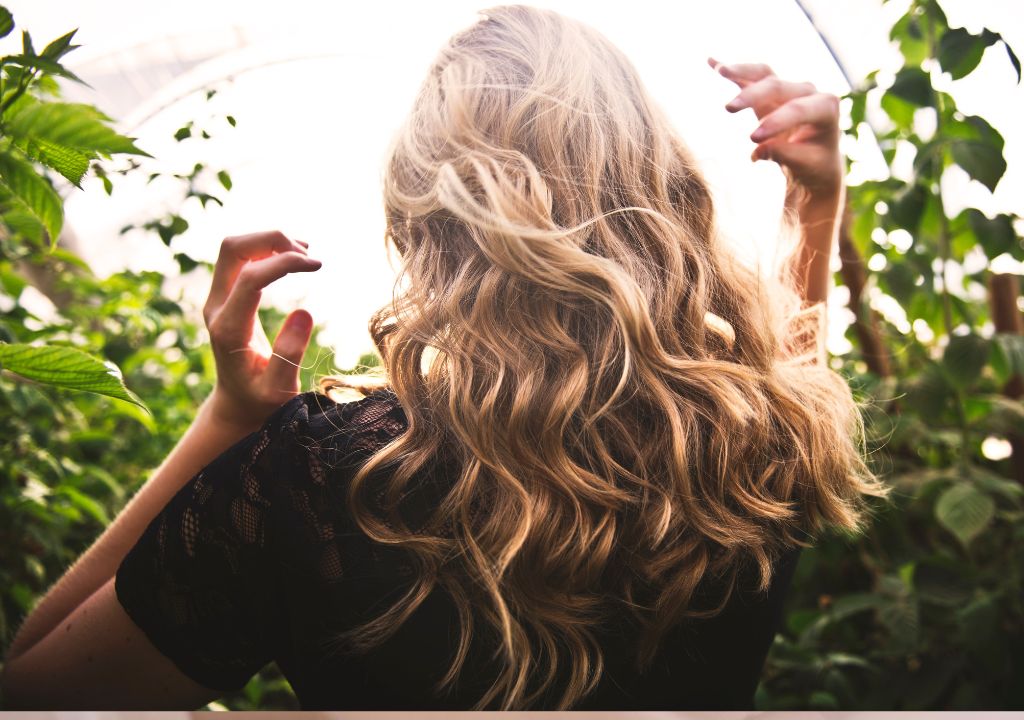 lady with long wavy hair walking around outside in nature
