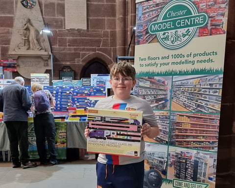 Image - Young model train enthusiast looking proud of his new train whilst at Making Tracks 3 at Chester Cathedral, Summer 2023