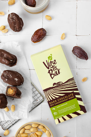 vine-to-bar-chocolate-bar-on-white-table-with-dates-and-peanuts