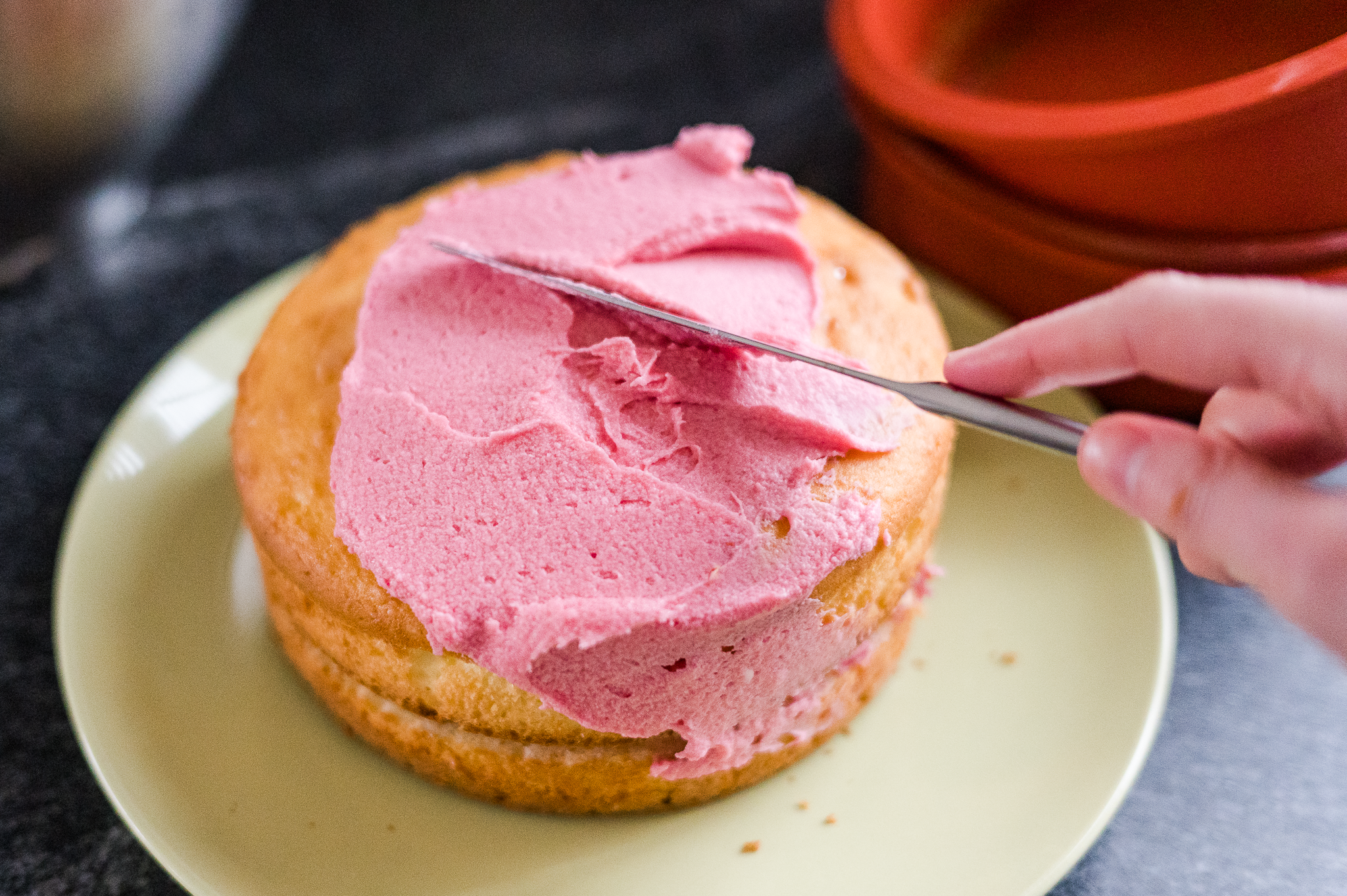 cake with frosting being added