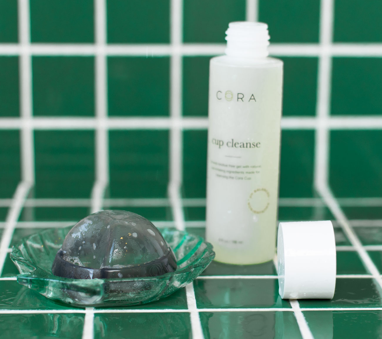 cora menstrual disc and cora cup cleanser on green tile 