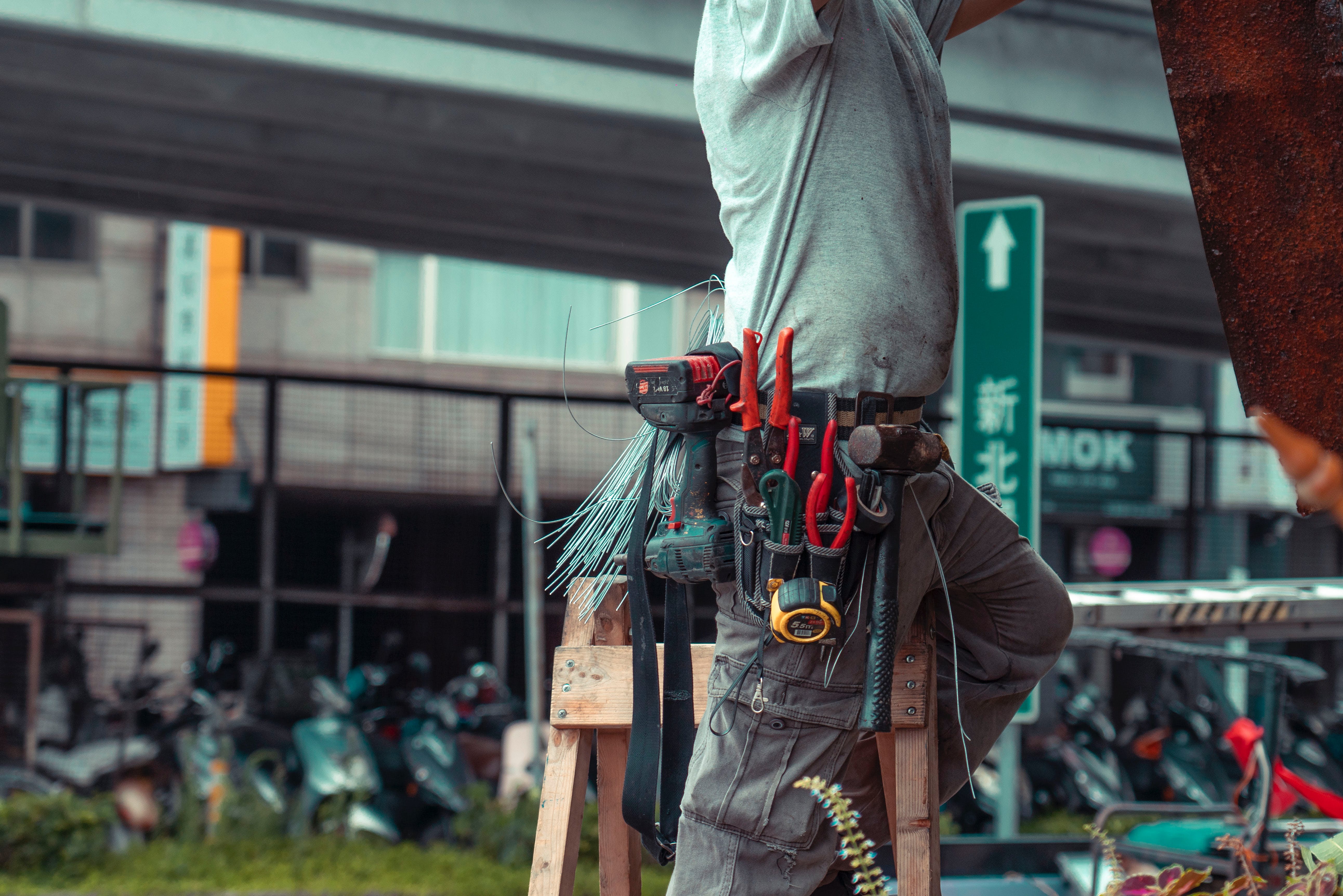 Worker on a stepladder with tools on a special belt