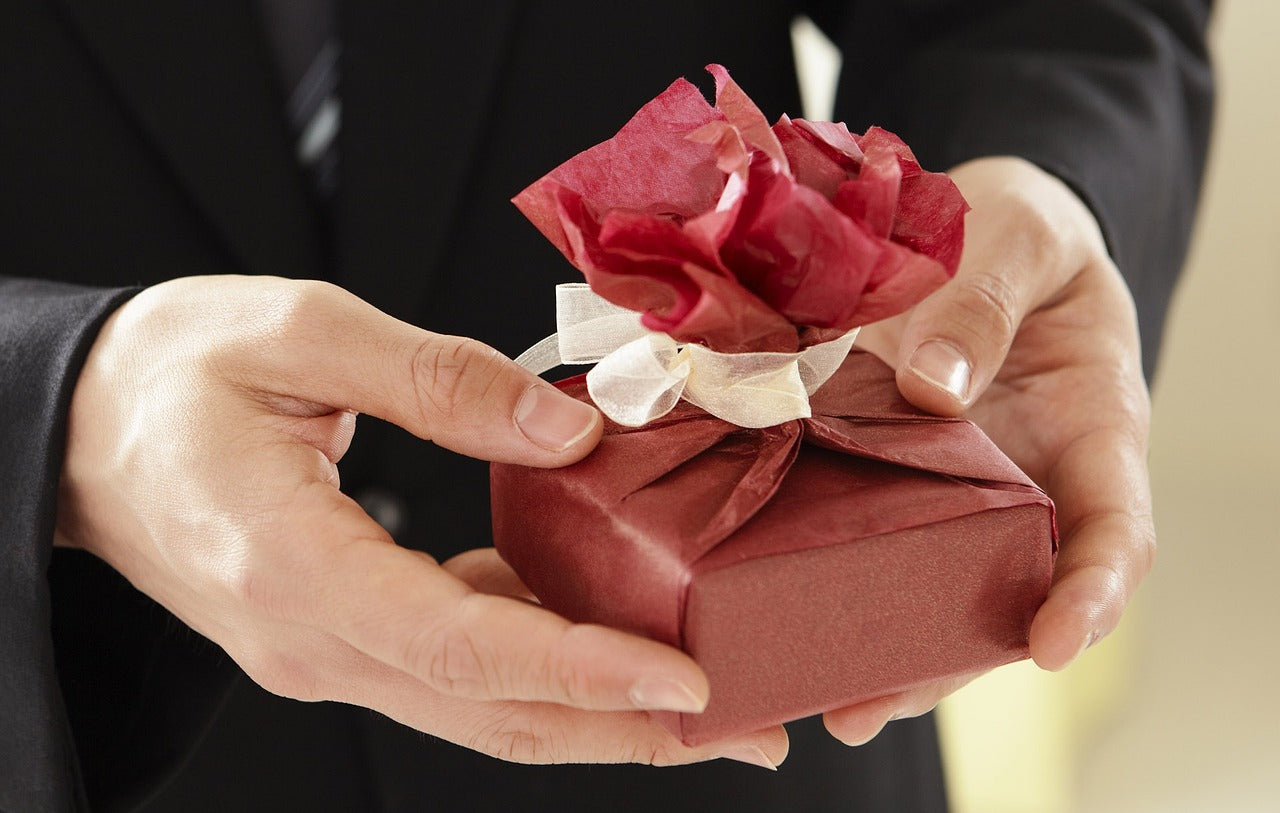 Small box in gift wrapping in hands