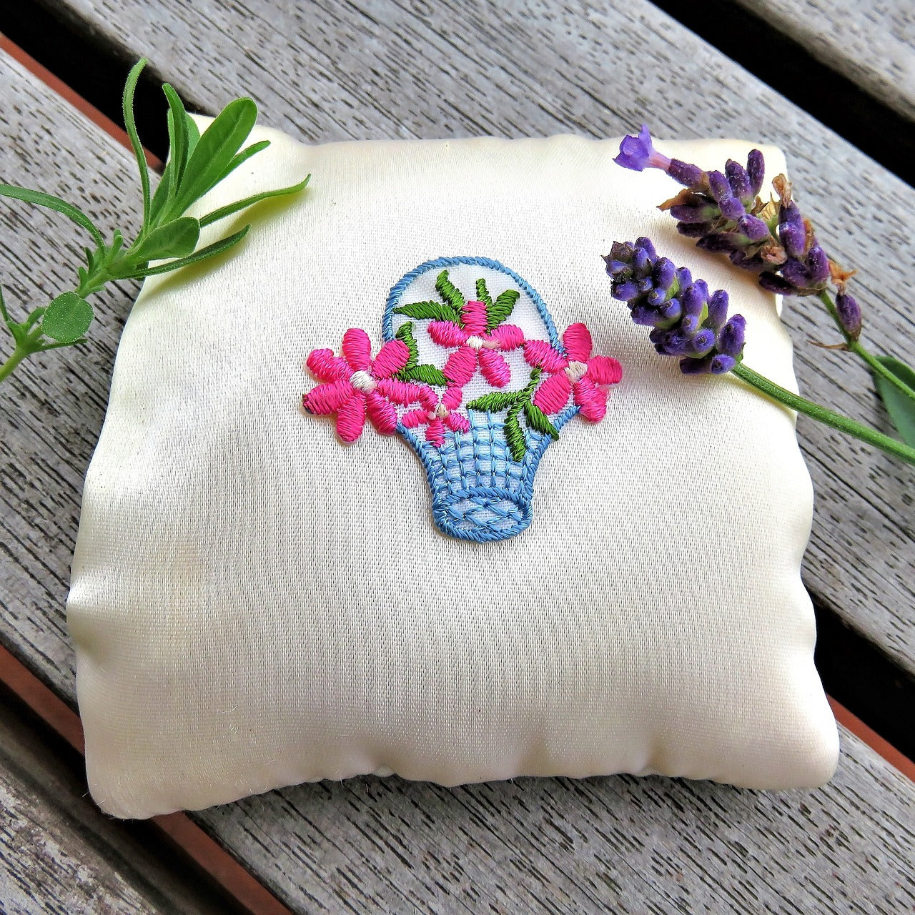 A purple flower lies on an embroidered pillow
