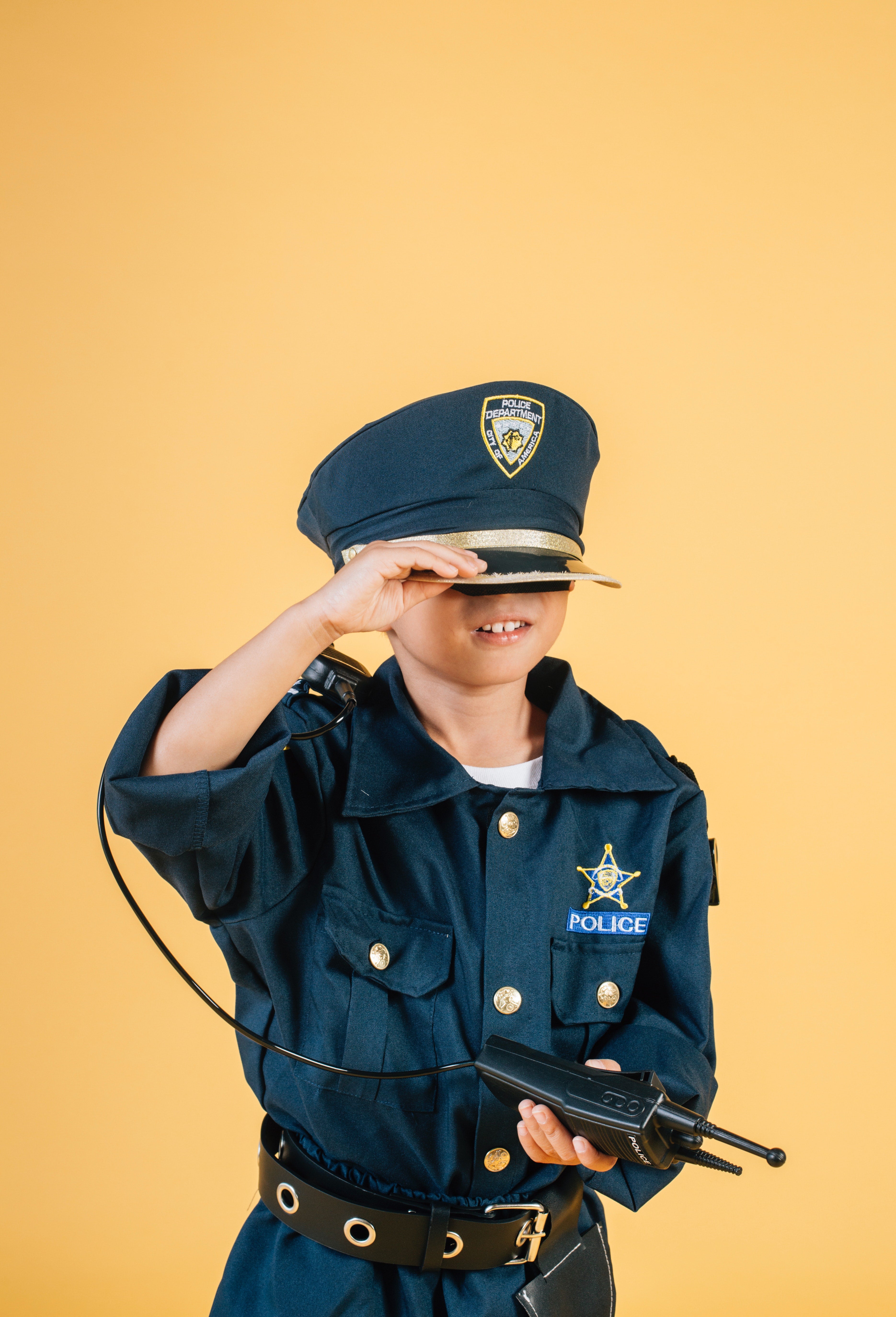 Boy dressed as a policeman with a walkie-talkie