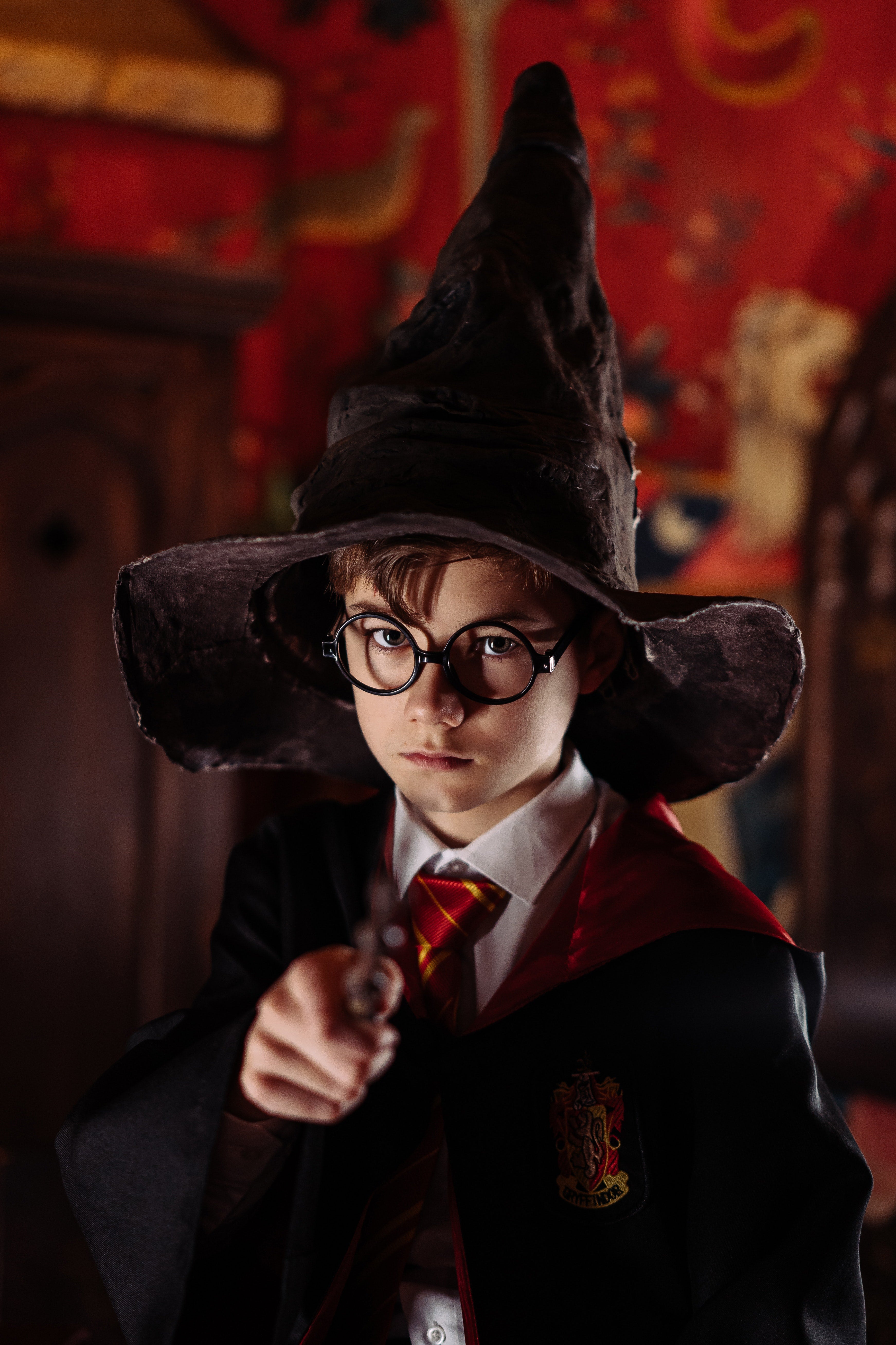 A boy in a Harry Potter costume and a tall black hat