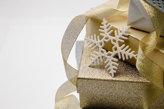 There is a large snowflake on a golden gift box