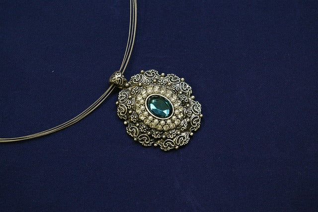 Carved pendant with green stone in the center