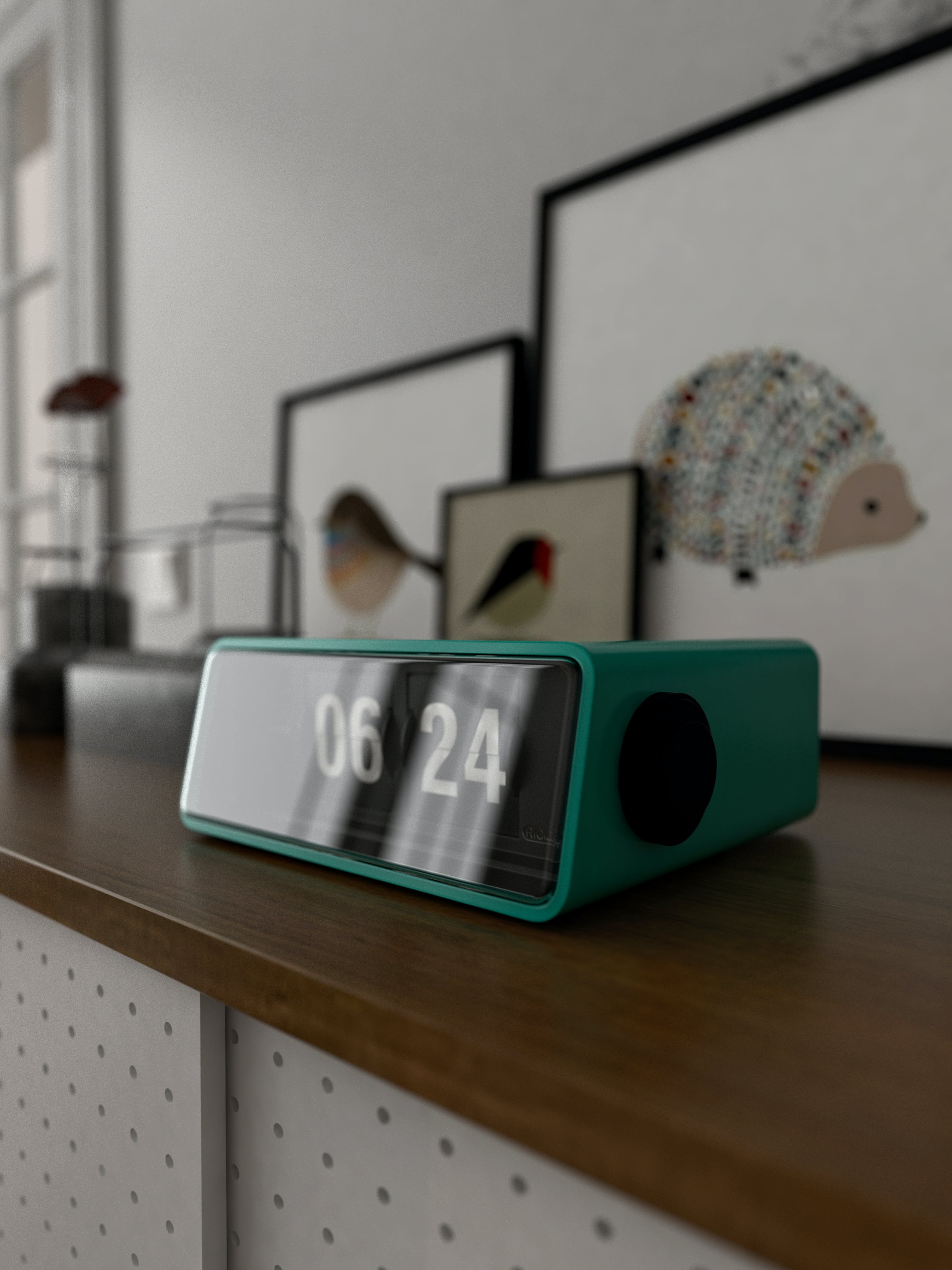 Digital alarm clock on the counter next to the paintings