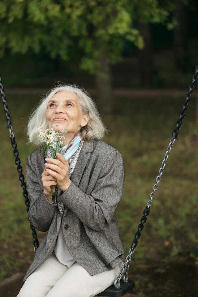 Woman with flowers sitting on a swing