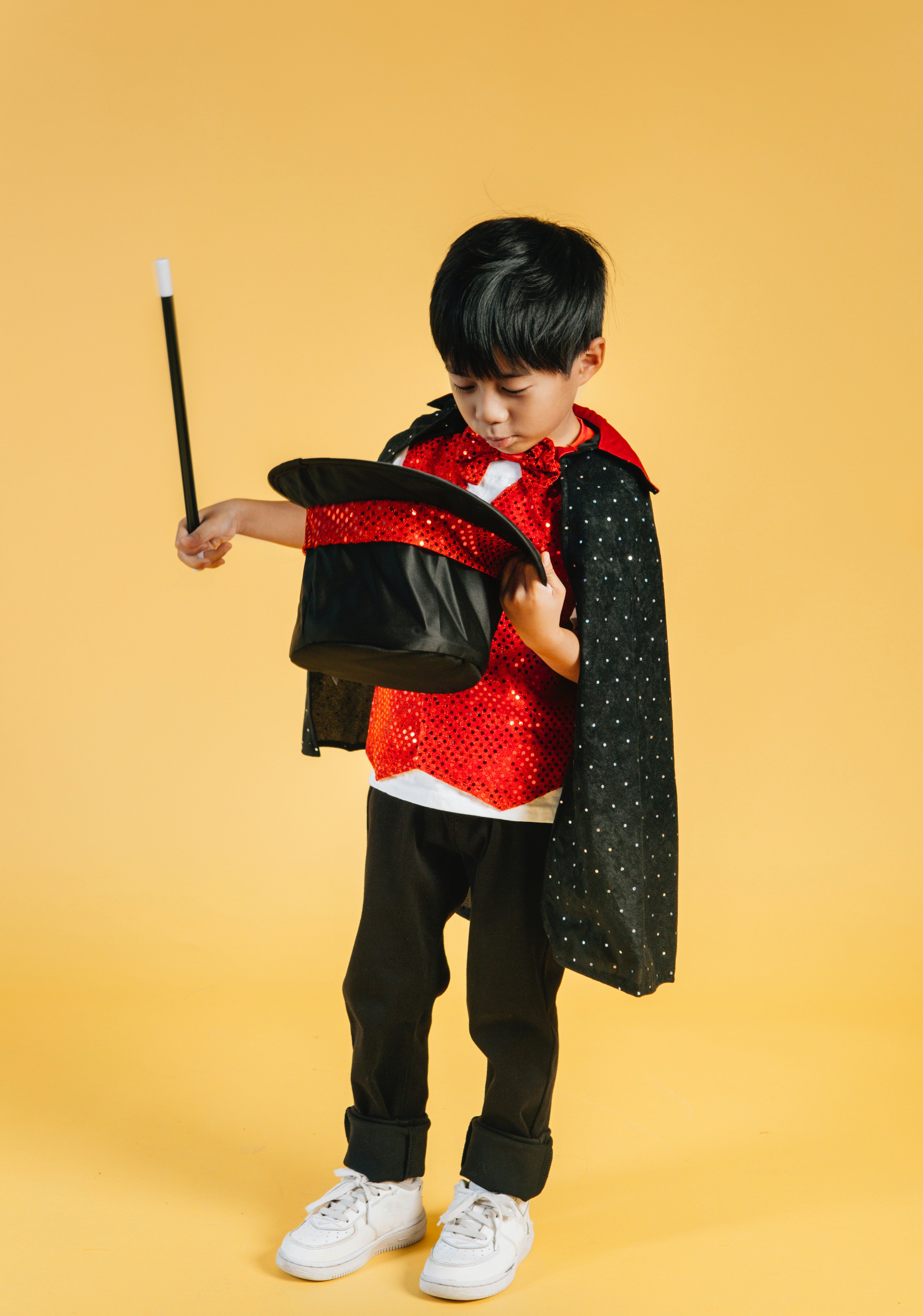 Boy in a magician's costume and with a wand in his hand