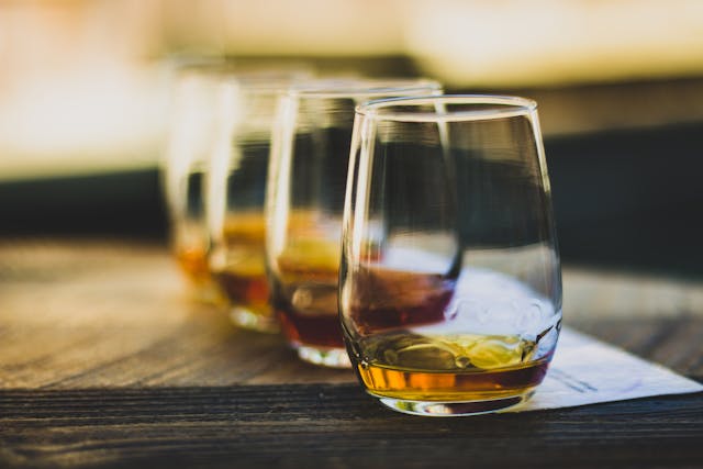 Glasses with a brown drink stand in a row on the table