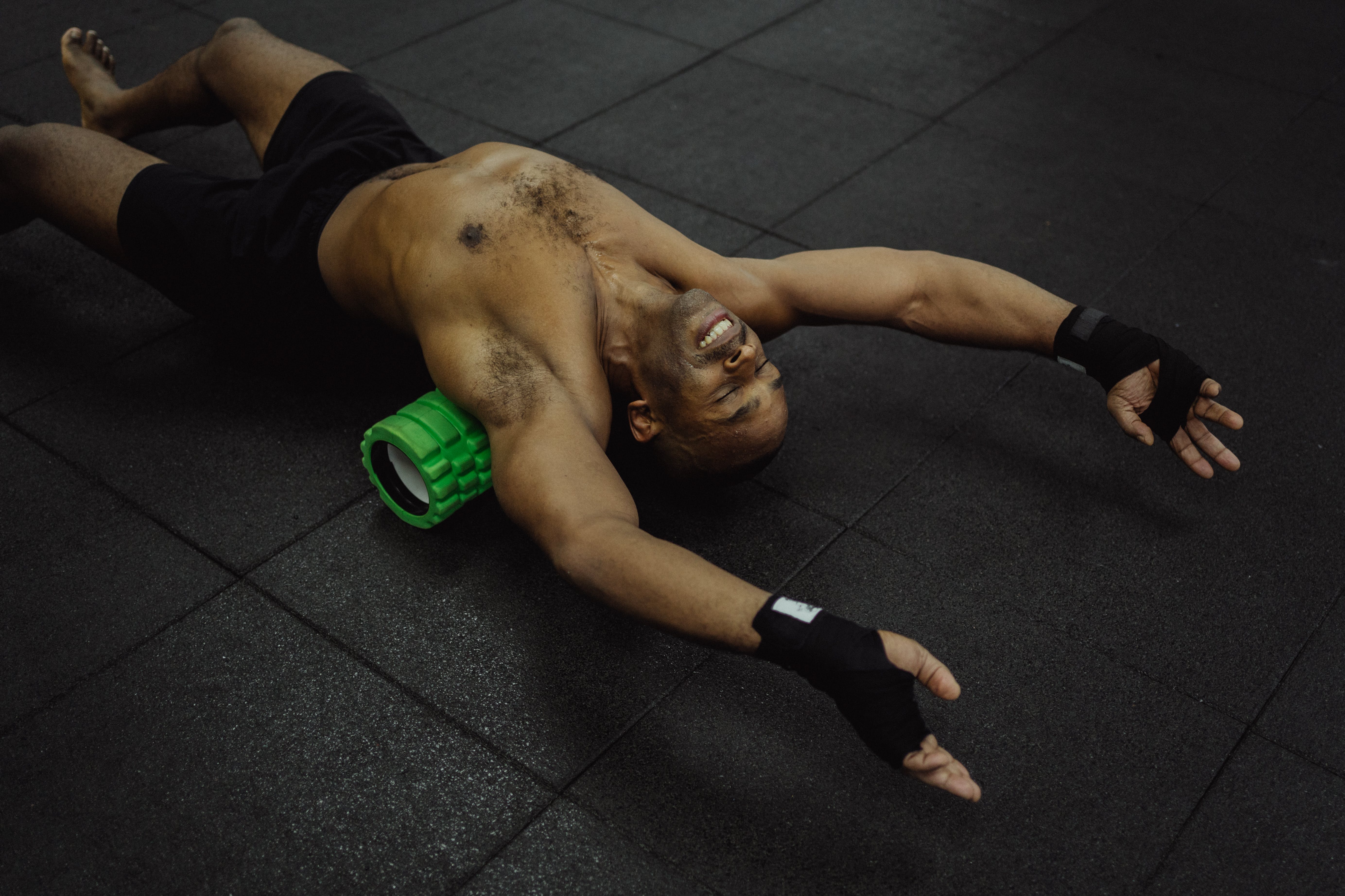 A man stretches his back on a plastic roller