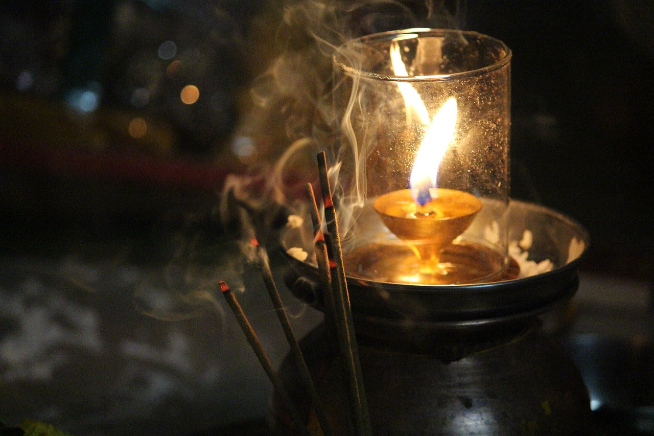 Candle in a glass flask and incense sticks