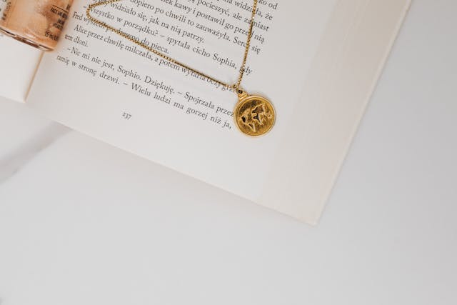 A pendant on a chain lies on an open book