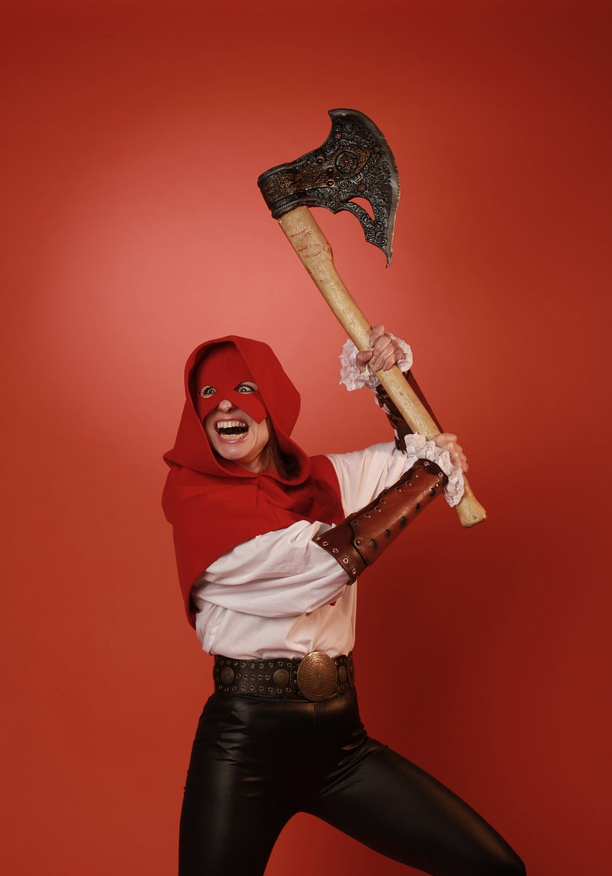 Woman dressed as an executioner lifts an ax