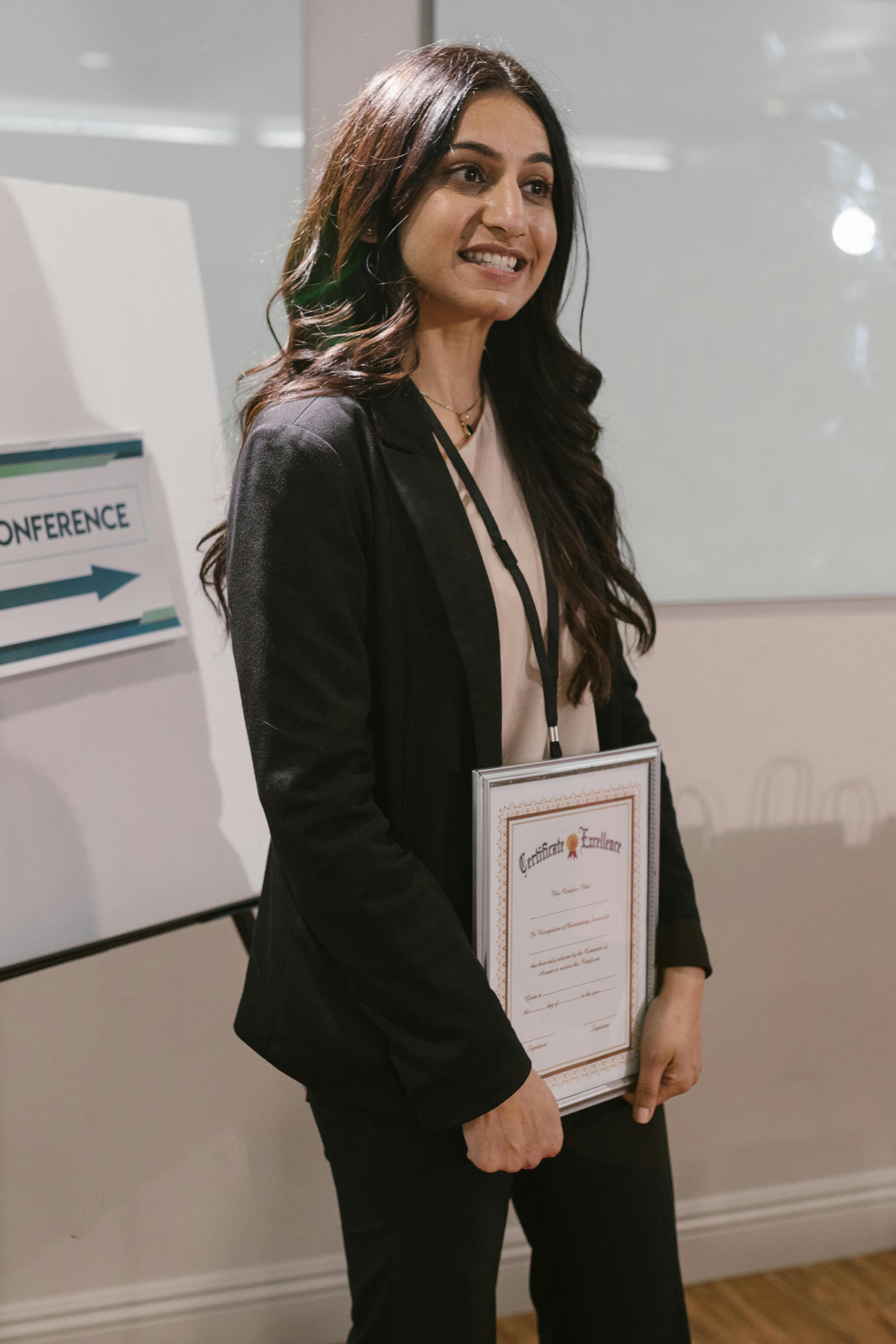 Woman in a business suit holding a diploma in her hands