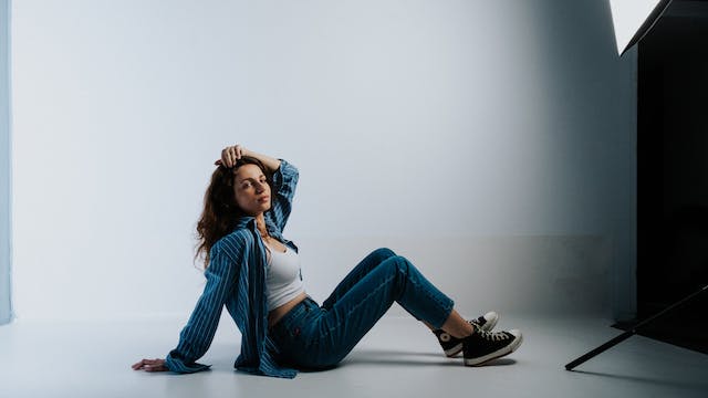  Woman in jeans and shirt sitting on the floor