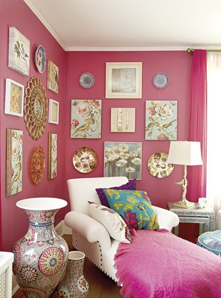 White armchair-bed in a room with pink walls hung with paintings