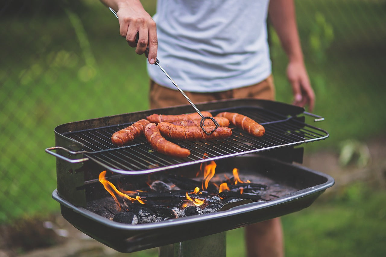 Man frying sausages on barbecue