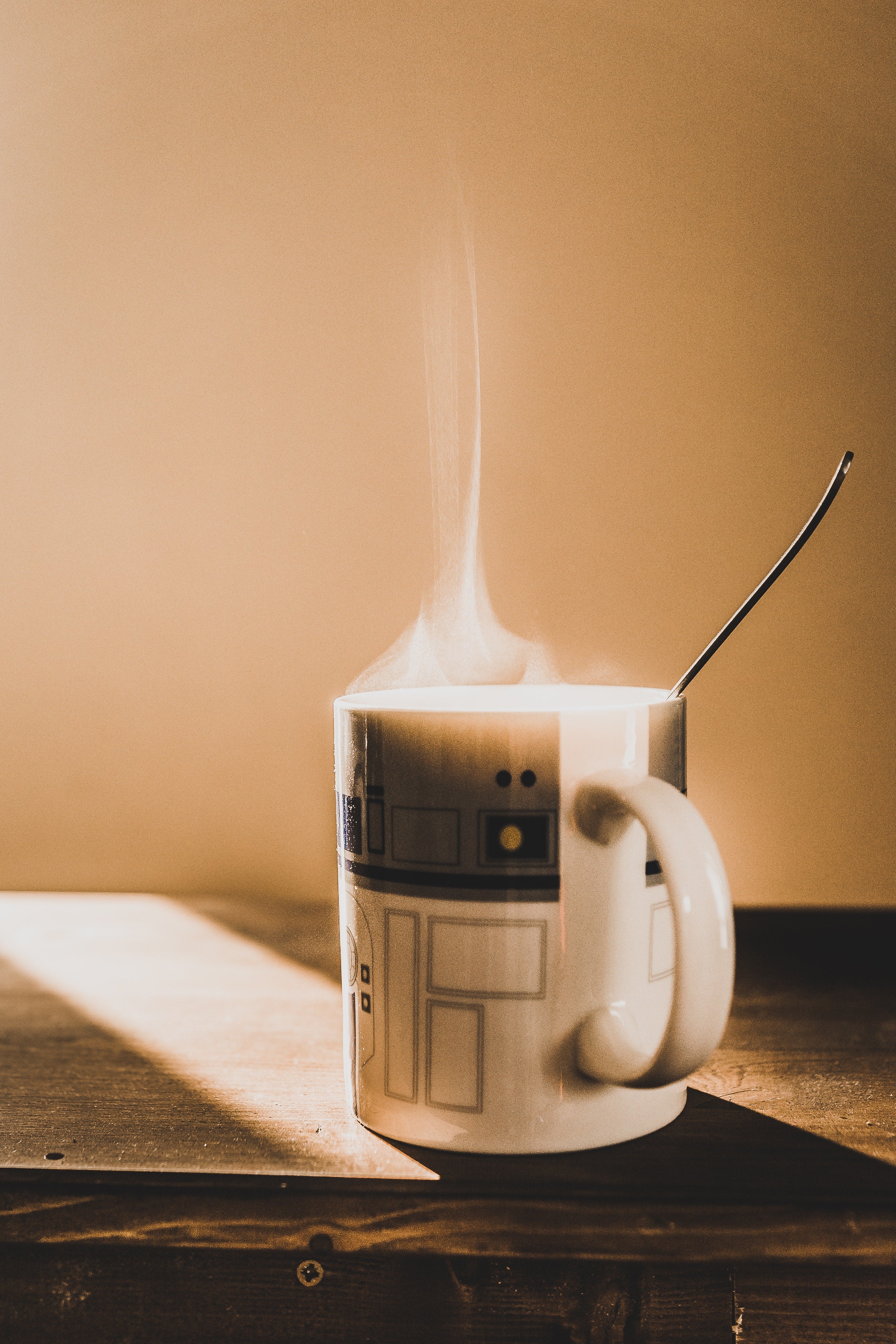 There is a cup on the table from which steam rises