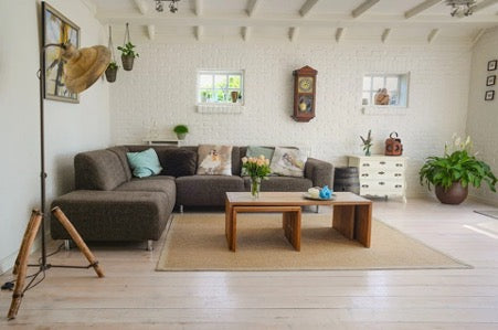 Bright room with a dark sofa and a wooden table in it