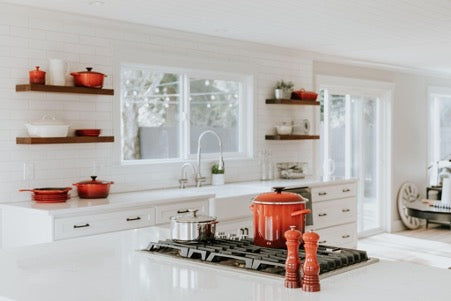 Large bright room with white furniture and red crockery