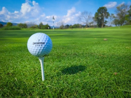  Golf ball stands on a stand on a green lawn