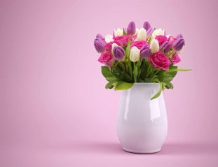 White vase with flowers on a pink background