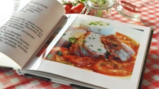 There is an open book with a picture of food on the table