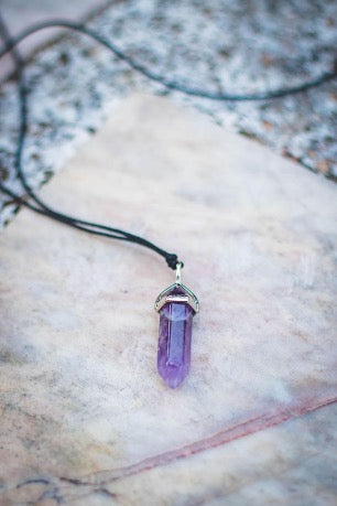 Purple pendant on a black cord