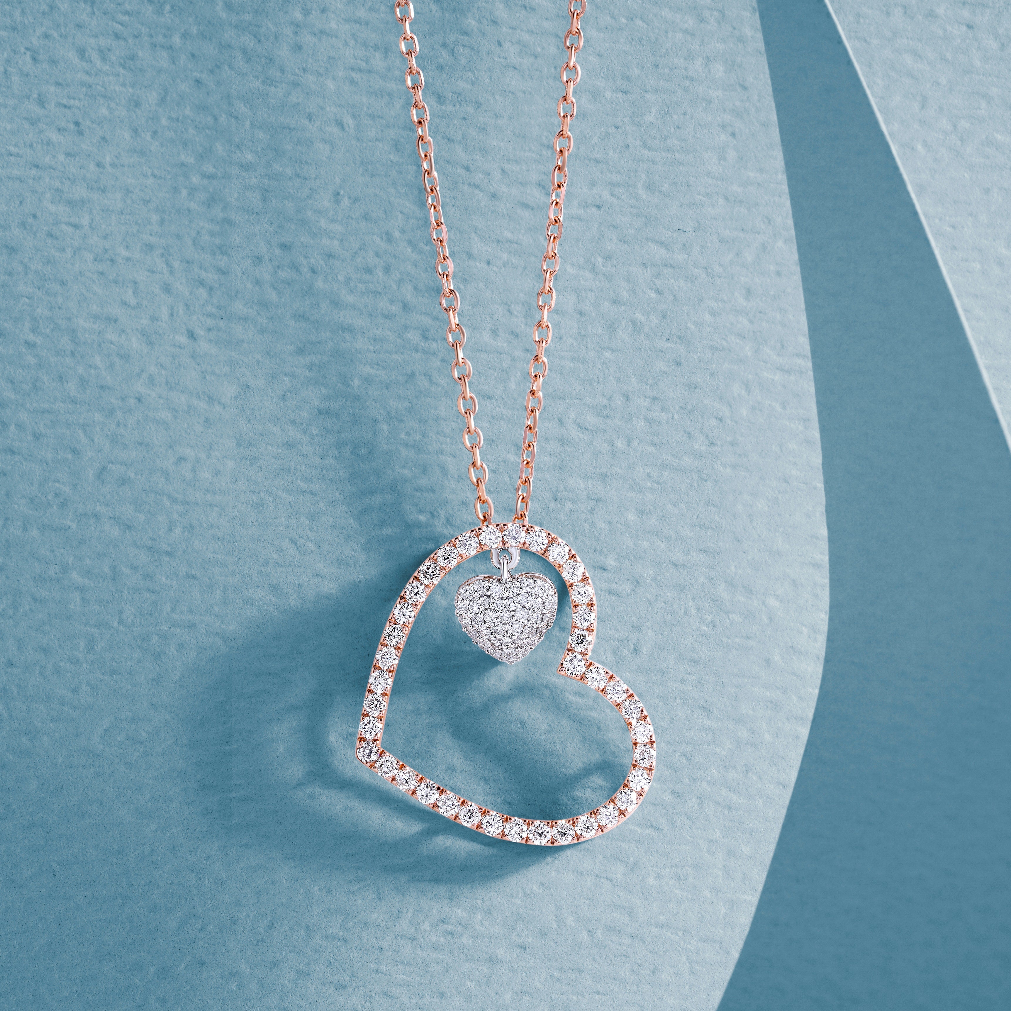  Pendant in the form of a heart in a heart on a chain on a blue background