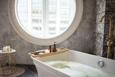  Bathroom with round window and bathtub with foam