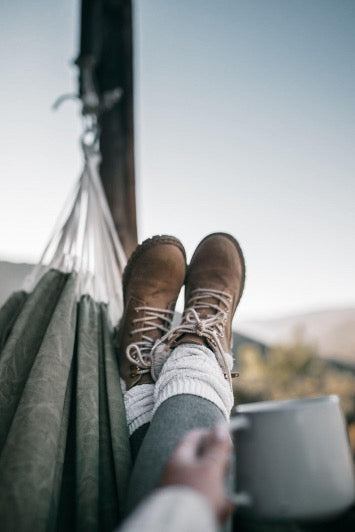 Feet in brown shoes in a hammock