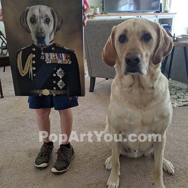 A man holds a portrait of a Labrador retriever, depicted in a historical veteran costume, and a Labrador retriever sits nearby