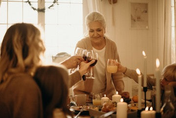 A group of people clink glasses at the festive table