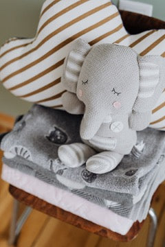 Toy elephant sits on a stack of towels