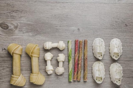 Different dog treats lie on the floor