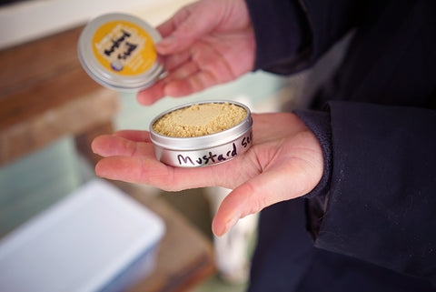 Mustard Seed in an old Green Goo Solar Goo sunscreen tin