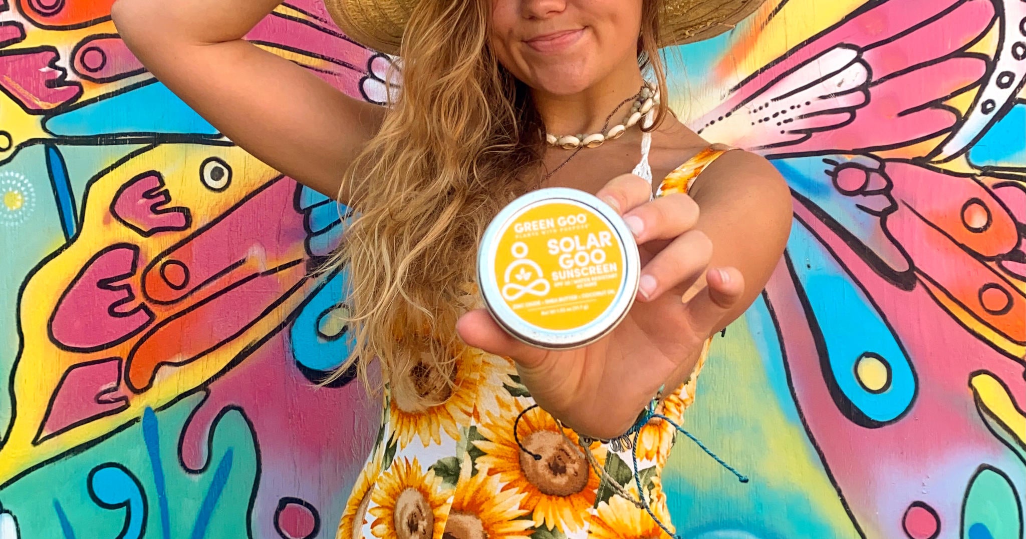 Green Goo's Solar Goo SPF30 Sunscreen large tin held by a young blonde female creator