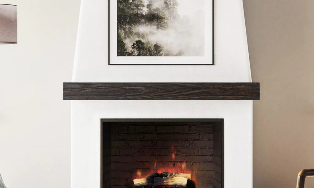 Simple wood mantel in a white fireplace surround with art over the mantel.