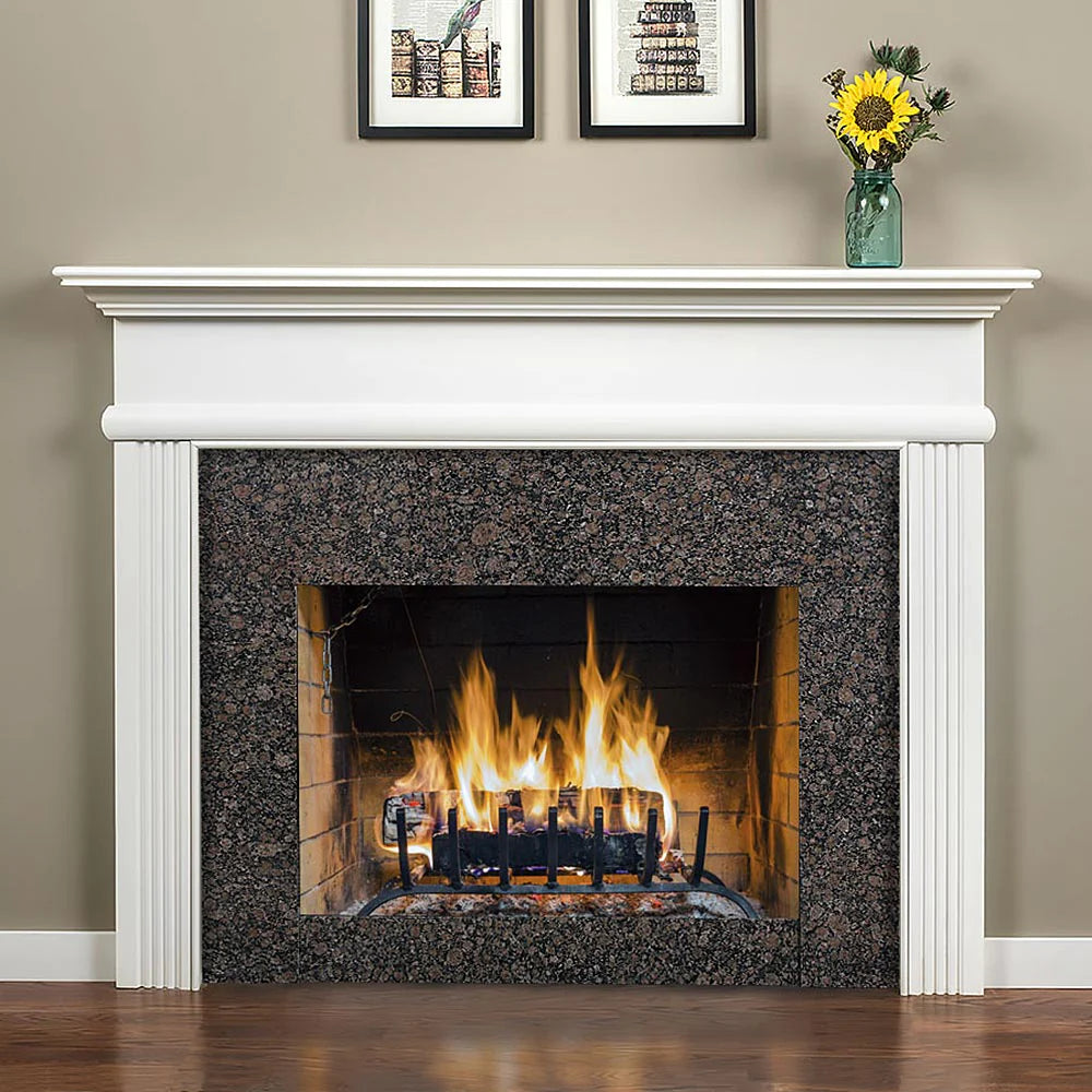 Fireplace with white mantel surround with fluted legs and granite facing.