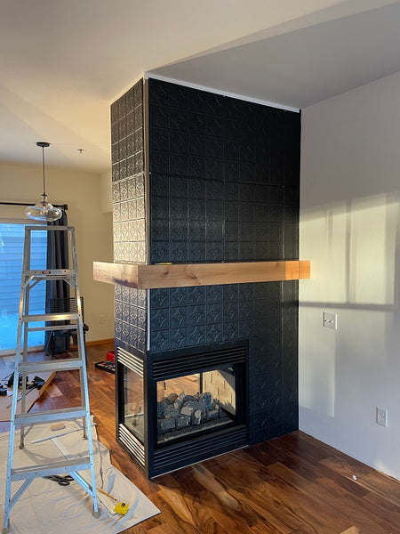 Peninsula fireplace after remodeling with black tin tile and alder mantel.